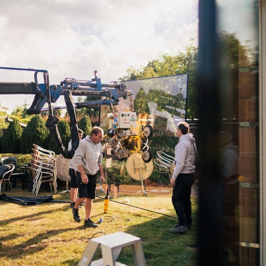 Callewaert team met kraanwagen bij montage grote glaspartij